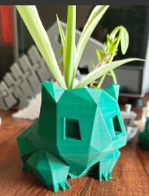 Green faceted planter with pointed ears and a plant