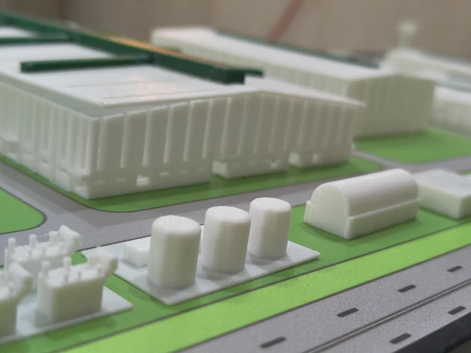 Close view of an industrial site model showing tanks, buildings and roads