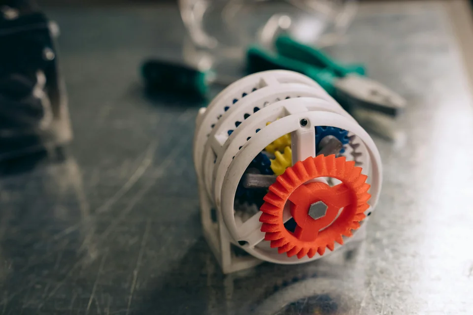 Printed mechanism with an orange gear and white curved frame